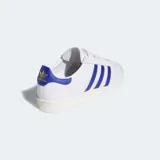 Championes Adidas Jabbar Lo de diseño clásico inspirado en los años 70. Presentan una parte superior de cuero blanco con las icónicas tres tiras laterales en azul, detalle en el talón a juego y puntera de gamuza gris claro. Cuentan con suela de goma y mediasuela de EVA para mayor comodidad.