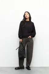 Sweater negro de punto con cuello alto y mangas abullonadas con puños elastizados.