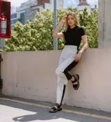 Sandalias de cuero color crudo con dos tiras horizontales en el empeine, una de cuero liso y otra con detalle dorado. Suela track color beige.