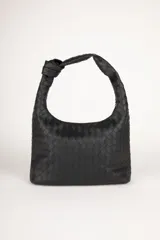 Cartera marrón de símil cuero trenzado con asa fija anudada. Cuenta con tres bolsillos interiores.