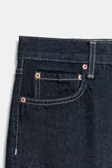 Jeans de tiro medio con corte recto y largo al tobillo. Presentan diseño de cinco bolsillos, cierre frontal con cremallera y botón, y ruedo deshilachado.