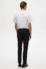 Pantalón tipo jogger de vestir negro, corte slim fit, con pliegues frontales y traseros, cintura elástica con cordón de ajuste y bolsillos laterales y traseros.