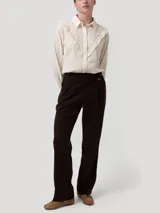 Pantalón recto de tiro alto color marrón, confeccionado con mezcla de lana y poliéster reciclado. Cuenta con pretina limpia, botón lateral decorativo y cierre invisible.