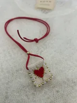 Collar con dije rectangular bordado con un corazón rojo y detalles de mostacillas de colores.