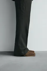 Bota corta de piel con acabado de serraje, diseño de horma cuadrada y tacón bloque de madera. Cuenta con cierre de cremallera lateral.