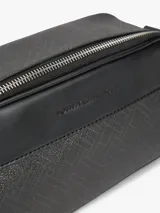 Morral Tommy Hilfiger color negro con diseño texturizado, paneles con mezcla de texturas y motivo integral de logos en relieve. Cuenta con cierre de cremallera, correa ajustable y logo metálico en la parte delantera.