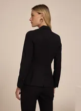 Blazer negro entallado de tela lisa, con solapas de pico, bolsillo frontal incorporado y solapas aplicadas, mangas largas, cierre de botones en la parte delantera y forro incorporado.