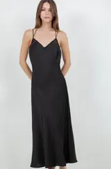 Vestido largo tipo slip dress confeccionado en tela satinada color negro, con escote en V y breteles finos.