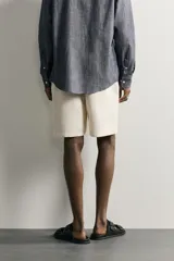 Bermuda de algodón en color beige, con corte relaxed fit, cintura elástica con cordón ajustable y bordado a tono en la pernera.