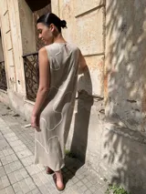 Vestido midi color beige, de corte recto y sin mangas, con estampado de líneas blancas.
