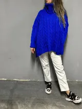 Sweater azul eléctrico de tejido de punto trenzado, cuello alto y corte oversize con aberturas laterales.