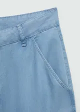 Pantalón wide leg de lyocell color celeste, tiro medio con trabillas para cinturón y bolsillos laterales. Presenta cierre delantero con cremallera y botón, además de costuras pespunteadas a lo largo de las piernas.