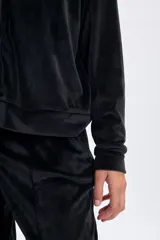 Campera de plush color negro con cierre frontal, capucha con cordones ajustables y mangas ranglan. Presenta un diseño cómodo y versátil con puños y ruedo acanalados.