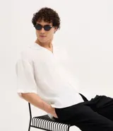 Camisa masculina blanca de lino, modelo boxy, con cuello bowling, manga corta y abotonado delantero.