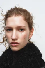 Pendientes tipo argolla con cierre de tuerca, combinando metal dorado en el aro y una bola plateada colgante.