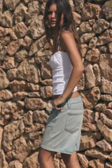 Bermuda de tiro medio confeccionada en denim de color negro gastado, con diseño de cinco bolsillos, trabillas para cinturón y cierre frontal con cremallera y botón metálico.