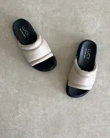 Sandalias bajas color beige, con capellada acolchada de cuero vacuno y plantilla anatómica.