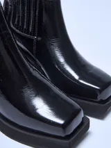 Botín negro de charol con elásticos laterales, punta cuadrada y taco bloque.