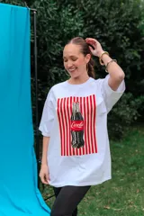 Remerón de algodón blanco con corte oversize y cuello redondo, que presenta un estampado frontal con diseño de una lata de sardinas sobre fondo de rayas.