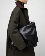 Abrigo largo de color verde militar con corte recto y tejido de efecto encerado. Posee cuello italiano de pana en contraste, cierre frontal oculto por solapa y bolsillos laterales inclinados.