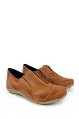 Zapato bajo de cuero negro con cierre frontal, costuras a la vista en color claro y suela de goma en tono beige.