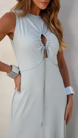Vestido largo celeste sin mangas, con escote redondo y abertura en el abdomen con detalle de cadena plateada.