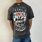 Remera de algodón con efecto lavado ácido, corte semi oversize y estampa gráfica en la espalda con el texto 'Welcome to Hell' y un diseño de garras sobre un globo terráqueo.