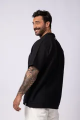 Chomba de manga corta con cuello polo, confeccionada en tejido de punto acanalado de textura pesada. Presenta un calce relajado y cuenta con una pequeña etiqueta distintiva en el ruedo.