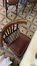 Cartera de mano tipo clutch, de cuero trenzado a mano en color negro y beige, con diseño de rayas verticales.