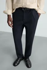 Pantalón chino de algodón color crema, corte regular fit, con cierre frontal de cremallera y botón, bolsillos delanteros y bolsillos traseros de vivo con botón.