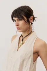 Vestido largo marrón, sin mangas, con cuello halter y bolsillos laterales.