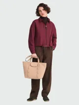 Bolso tote de cuero color beige, tamaño M, con asas de mano y solapa con cierre de broche a presión.