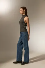 Top tejido de punto color gris oscuro con cuello alto tipo polera y diseño sin mangas con corte halter.