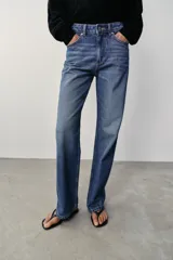 Jeans de tiro alto, pernera recta y larga, estilo clásico con cinco bolsillos, cierre frontal con cremallera y botón metálico.