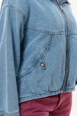 Campera de jean color celeste con silueta relajada y calce amplio. Presenta cierre frontal metálico, cuello clásico y bolsillos laterales.
