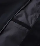 Campera negra de poliéster con cuello mediano, cierre por cremallera, manga larga con ajustes y bolsillos. Cuenta con tecnología repelente al agua.