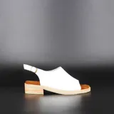 Sandalias amarillas de cuero con puntera abierta, taco bajo de madera y tira trasera con hebilla.