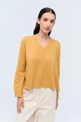 Sweater de tejido de punto color beige, con escote en V y calce holgado.