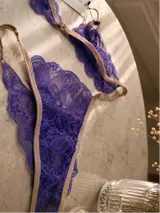 Conjunto de lencería de encaje violeta con tiras elásticas en tono tostado, compuesto por un soutiene bralette y bombacha a juego.