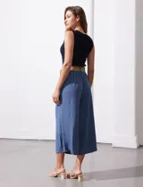 Pantalón capri de gasa bambula color beige, marca Dictionary. Tiene pretina ancha con elástico en la parte trasera, bolsillos delanteros y corte de pierna ancha. Incluye cinturón de rafia con hebilla redonda.