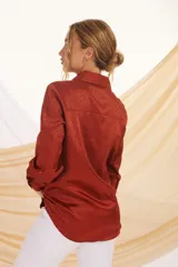 Camisa beige con estampado de líneas diagonales, cuello clásico, cierre con botones y mangas largas con puños abotonados.