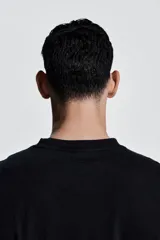 Remera deportiva negra de corte boxy, confeccionada en tejido funcional DryMove™ con efecto lavado. Tiene cuello redondo ribeteado acanalado y hombros caídos.