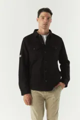 Chaqueta azul marino de paño con cuello clásico, cierre frontal con botones, dos bolsillos de parche en el pecho con solapa abotonada y bolsillos laterales.