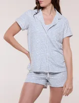 Set de pijama compuesto por musculosa de tirantes finos y short con cordón ajustable, de base blanca con estampado floral en tonos rosados.