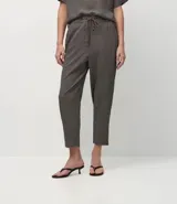 Pantalón de corte sastre y estilo fluido, confeccionado en crepé con estampado pied-de-poule. Presenta cintura elástica con cordón de ajuste y bolsillos laterales.