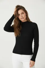 Polera de viscosa negra, de tejido acanalado (canalé), corte ajustado al cuerpo y cuello alto.