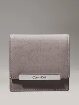 Billetera Calvin Klein de plegado triple, color gris con monograma de la marca en toda la superficie y barra plateada con el logo grabado.