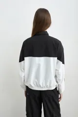 Campera estilo aviador de tela avión, en diseño bicolor negro y blanco, con cierre frontal y cuello alto. Cuenta con bolsillos laterales con cierre y bordado de la marca Mandinga en el pecho.