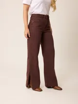 Pantalón jean de tiro alto y corte recto, color marrón chocolate, con aberturas laterales en el ruedo.