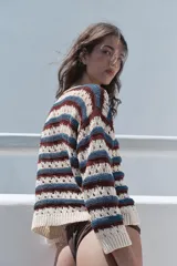 Chaqueta de punto calado con cuello redondo, manga larga y diseño a rayas horizontales en tonos blanco, azul y bordó. Cuenta con cierre frontal de botones y terminaciones en rib.
